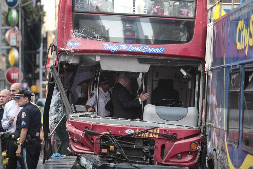 Un autobús rojo de dos pisos siniestrado en un accidente de autobús en Brooklyn, con equipos de emergencia y agentes de policía en el lugar, poniendo de relieve el caos de un accidente de transporte público.
