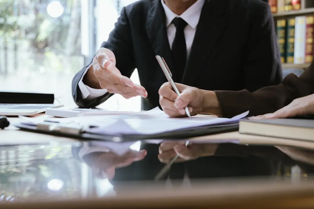 Close-up of New York personal injury lawyer at desk with contract documents, medical records, and wooden gavel, preparing a strong compensation claim